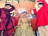 A beautiful sight : This bride looks stunning in her golden lehenga and red dupatta. Accompanied by her closest family members, she makes her way to meet her groom. The chunar over her head complements her wedding dupatta.